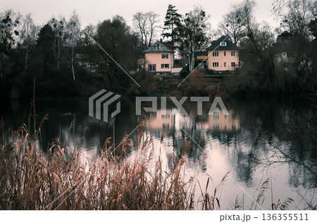 Houses Reflected in Calm River in Quiet Suburban Area 136355511