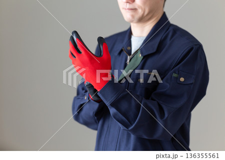 グローブをはめる作業服のミドル男性ビジネスマン 136355561