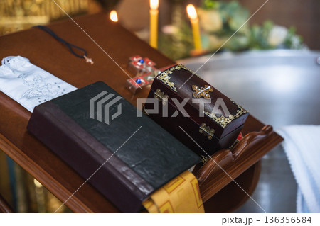 Orthodox Funeral Ceremony Table With Bible Cross Candles and Wooden Casket Box Shallow Depth of Field Warm Light Sacred Atmosphere 136356584