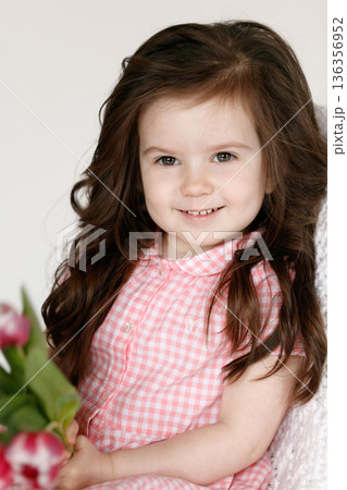 Little girl with bouquet of pink tulips Little girl with bouquet of pink tulips 136356952