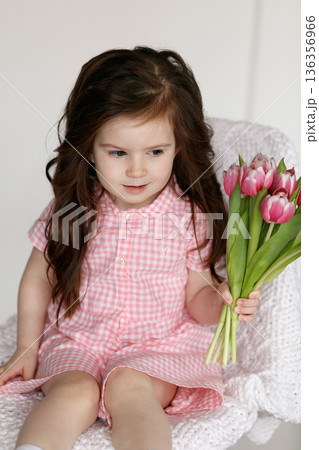 Little girl with bouquet of pink tulips Little girl with bouquet of pink tulips 136356966
