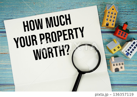 Notepad with "How Much Your Property Worth?" with magnifying glass and house model on wooden background Notepad with "How Much Your Property Worth?" with magnifying glass and house model on wooden background 136357119