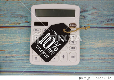 Special Discount 10% off Shop Now with price tag and calculator on wooden background 136357212