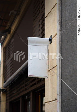 Street banner mockup hanging on a building wall, offering a customizable advertising space for businesses, promotions, or branding in an urban architectural context 136357230