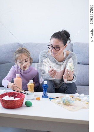 Mother and daughter painting Easter eggs 136357869
