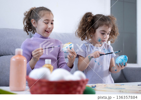 Two sisters decorating Easter eggs. Two sisters decorating Easter eggs. 136357884