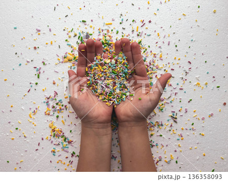 a child's palms covered in sugar of various shapes and colors a child's palms covered in sugar of various shapes and colors 136358093