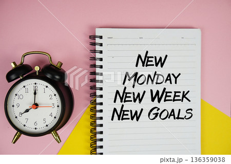 New Monday New Week New Goals text written on notepad with alarm clock on pink background 136359038