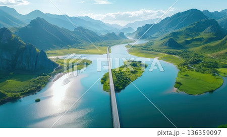 Aerial view of a winding river through a valley, surrounded by lush green mountains. Aerial view of a winding river through a valley, surrounded by lush green mountains. 136359097