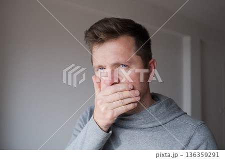 Man covering his mouth with hand trying to keep a secret and stay silent 136359291