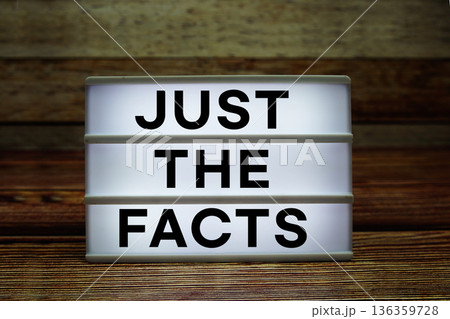 Lightbox with text "Just The Facts" on wooden background Lightbox with text "Just The Facts" on wooden background 136359728