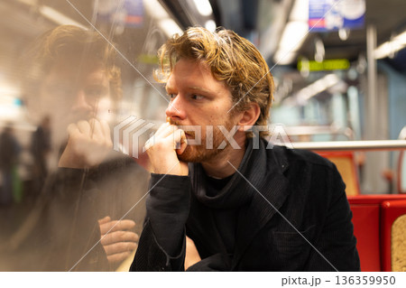Man looking contemplative while riding train commute Man looking contemplative while riding train commute 136359950
