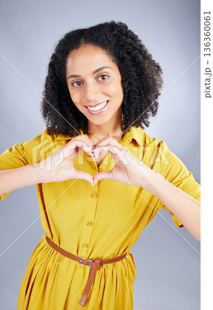 Heart, sign and happy woman for fashion portrait with thank you, support and hands emoji on a white background. Face, trendy clothes and young african person or model with self care or love in studio Heart, sign and happy woman for fashion portrait with thank you, support and hands emoji on a white background. Face, trendy clothes and young african person or model with self care or love in studio 136360061