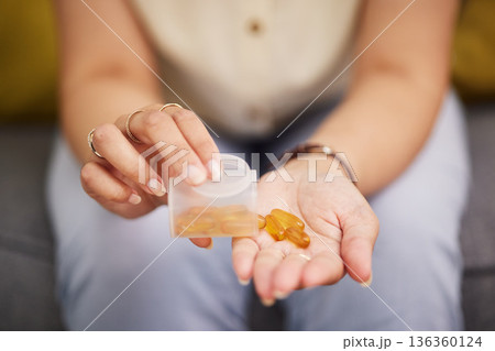 Hands, pills and a person with fish oil for health, wellness and medicine for diet. Closeup, bottle and a woman with medication or a healthcare supplement in the morning for medical goals or support 136360124