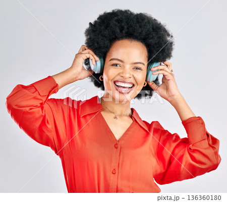 Portrait, black woman and music headphones in studio for podcast, audio and subscription on white background. Face of happy female model listening to album, streaming sound and hearing song on radio 136360180