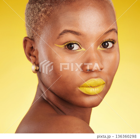 Beauty, makeup and portrait of a woman in a studio with eyeliner and lipstick for cosmetology. Self care, cosmetic and young African female model with a colorful face routine by a yellow background. Beauty, makeup and portrait of a woman in a studio with eyeliner and lipstick for cosmetology. Self care, cosmetic and young African female model with a colorful face routine by a yellow background. 136360298