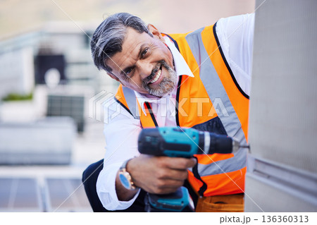 Solar panels, man and portrait with drill for maintenance of building, power box and upgrade in city. Happy electrician, construction tools and engineering of electrical system, generator and rooftop Solar panels, man and portrait with drill for maintenance of building, power box and upgrade in city. Happy electrician, construction tools and engineering of electrical system, generator and rooftop 136360313