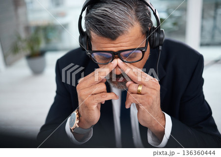 Depressed, tired and man in a call center with a headache from telemarketing or technical support. Sad, fail or a mature customer service employee or boss with a mistake or anxiety with communication 136360444