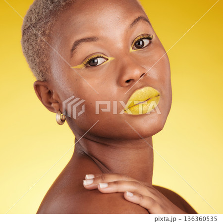 Portrait, skincare and cosmetics with african girl for glow in yellow studio or background in closeup. Woman, serious and beauty face with creative art or makeup for luxury treatment with eyeliner. 136360535