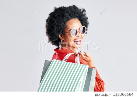 Happy black woman, afro and shopping bags for discount, sale or fashion deal against a white studio background. Portrait of African female person, customer or shopper smile for purchase in happiness Happy black woman, afro and shopping bags for discount, sale or fashion deal against a white studio background. Portrait of African female person, customer or shopper smile for purchase in happiness 136360564