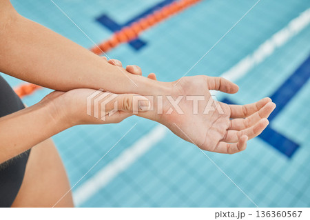 Hand, wrist pain and a swimmer by a pool in the gym closeup after emergency or accident during training. Fitness, water and a swimming athlete with an injury, arthritis or tendinitis in her arm 136360567