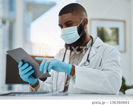 Doctor, black man and tablet in office for medical review, data research or healthcare app. Hospital physician with face mask planning on digital technology for telehealth, consulting and information Doctor, black man and tablet in office for medical review, data research or healthcare app. Hospital physician with face mask planning on digital technology for telehealth, consulting and information 136360661