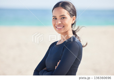 Arms crossed, beach and portrait of happy woman by the ocean ready for surf, exercise and workout. Female person, focus and face of a athlete from Hawaii outdoor by the sea in nature with training 136360696