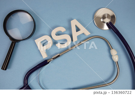 PSA abbreviation of Prostate Specific Antigen alphabet letters with magnifying glass and stethoscope on blue background 136360722