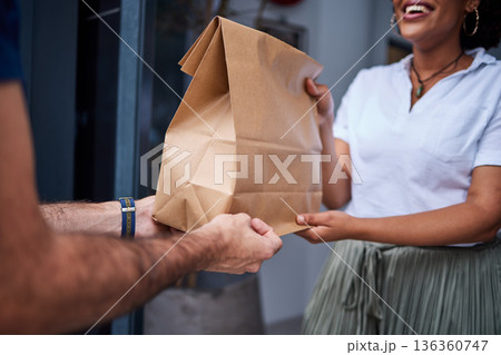 Delivery, customer and hands with a paper bag at door from courier man at home. Giving woman or a client a package, parcel or fast food from online shopping, e-commerce or distribution service 136360747