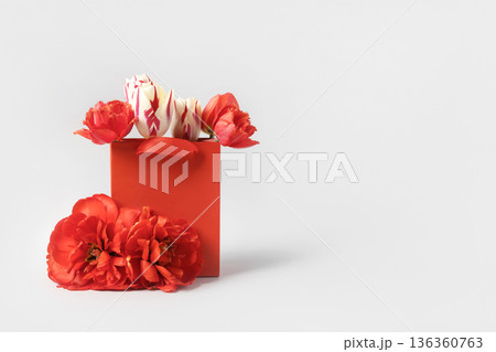 Red shopping and gift bag with red tulip flowers. Concept Valentine's day, gift package and delivery. Sale, shopping, promotion, pleasant surprises, black friday 136360763