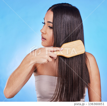 Hair care, beauty and a woman with a brush in studio for self love, hygiene and shine. Salon, hairdresser and a female model person with shampoo, cosmetics and a hairbrush on a blue background Hair care, beauty and a woman with a brush in studio for self love, hygiene and shine. Salon, hairdresser and a female model person with shampoo, cosmetics and a hairbrush on a blue background 136360851