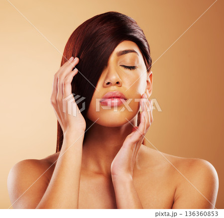 Hair care, beauty and a woman in studio for salon, hairdresser and wellness results. Self care, cosmetics and shampoo for growth and shine of an aesthetic model person on a brown background 136360853