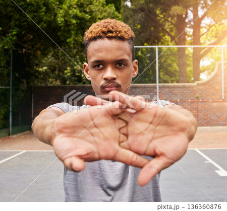 Sports, basketball and man stretching on court for competition, training or fitness games. Face of serious male athlete, player and warm up arms for workout, thinking of performance action or contest 136360876