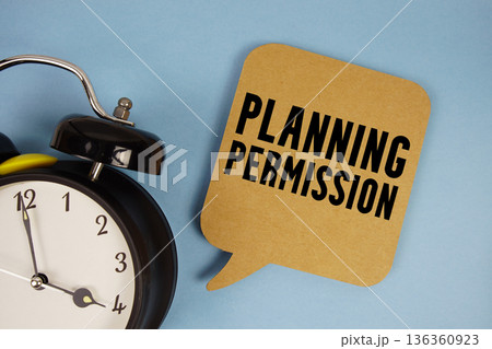 Planning Permission text with alarm clock on blue background Planning Permission text with alarm clock on blue background 136360923