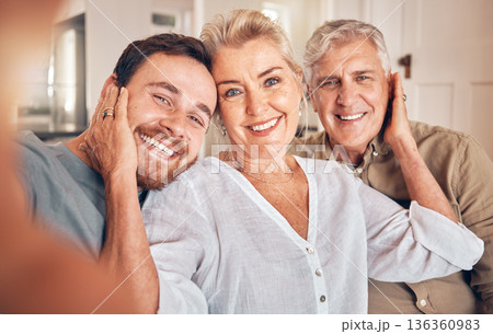 Man, elderly parents and selfie in home, portrait and embrace with love, care and bonding for post on web. Family house, mother and father with son for profile picture, photography and social network Man, elderly parents and selfie in home, portrait and embrace with love, care and bonding for post on web. Family house, mother and father with son for profile picture, photography and social network 136360983
