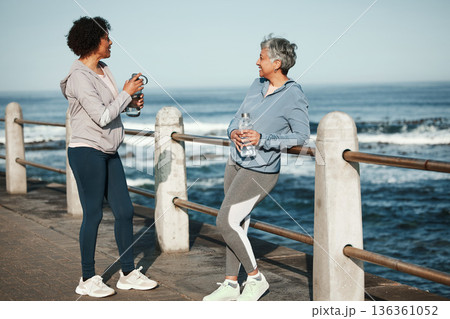 Fitness, walking and senior women relax by ocean for healthy lifestyle, wellness and cardio on promenade. Sports, friends and female people talking on boardwalk for exercise, training and workout 136361052