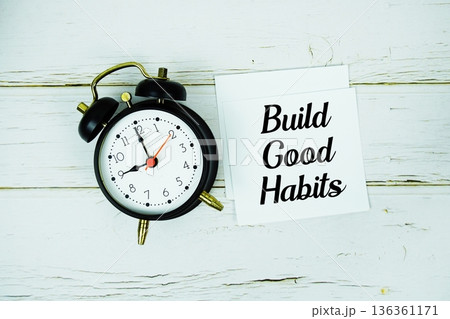 Build Good Habits text message on paper with alarm clock on wooden background 136361171