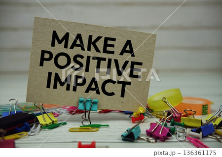 Make A Positive Impact text on paper card with stationary on wooden background Make A Positive Impact text on paper card with stationary on wooden background 136361175