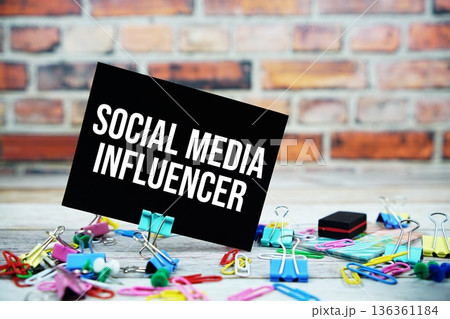 Social Media Influencer text on paper card with stationary on wooden background 136361184