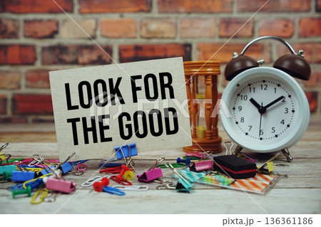 Look For The Good text on paper card with alarm clock and stationary on wooden background 136361186