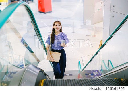 エスカレーターに乗る女性 エスカレーターに乗る女性 136361205
