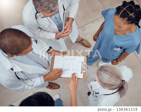 Group of doctors, nurses and checklist in hospital from above, meeting and planning surgery or schedule. Healthcare, discussion and medical staff with clipboard, info and talking together in clinic. Group of doctors, nurses and checklist in hospital from above, meeting and planning surgery or schedule. Healthcare, discussion and medical staff with clipboard, info and talking together in clinic. 136361319