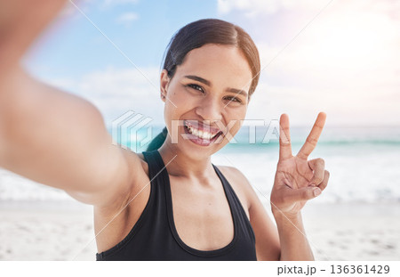 Exercise, selfie and woman at beach with peace hands for running, sports or fitness in nature. Portrait, happy and lady health and wellness influencer smile for social media, blog or profile picture 136361429