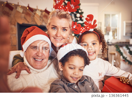Christmas, portrait and selfie of grandparents with children in home, bond and happy together. Xmas, face and grandma and grandpa with kids, interracial and profile picture for celebration of holiday 136361445