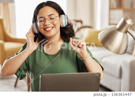Laptop, music and headphones with a woman in her home, listening to the radio in the living room to relax. Computer, audio and streaming with a young female student in her house for education Laptop, music and headphones with a woman in her home, listening to the radio in the living room to relax. Computer, audio and streaming with a young female student in her house for education 136361447
