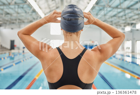 Woman, back and ready by swimming pool for fitness competition, training and gym exercise. Athlete, swimmer and person with water sports gear, cap and swimsuit in workout challenge, race and practice Woman, back and ready by swimming pool for fitness competition, training and gym exercise. Athlete, swimmer and person with water sports gear, cap and swimsuit in workout challenge, race and practice 136361478