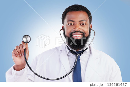 Portrait, stethoscope and man doctor in studio with cardiovascular, exam or consultation on blue background. Heart, health and African male surgeon with medical tool for heartbeat and breathing Portrait, stethoscope and man doctor in studio with cardiovascular, exam or consultation on blue background. Heart, health and African male surgeon with medical tool for heartbeat and breathing 136361487