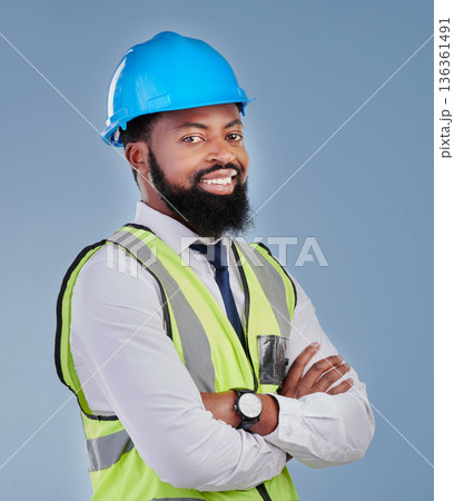 Construction, black man and portrait with arms crossed in studio for building inspection, engineering or industrial development. Happy male architect, contractor or project manager on blue background 136361491