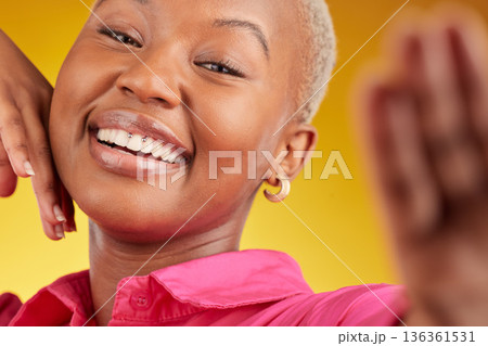 Selfie, smile and african girl with confidence or excited for social media in yellow background studio in closeup. Portrait, happy face and woman for video call, blog, photography or influencer. Selfie, smile and african girl with confidence or excited for social media in yellow background studio in closeup. Portrait, happy face and woman for video call, blog, photography or influencer. 136361531