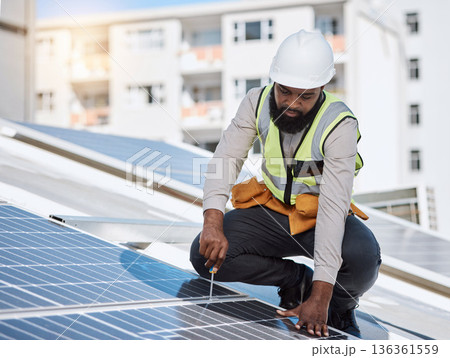 African engineer man, screwdriver and solar panel on roof for maintenance, industry or thinking in city. Technician, builder and tools for photovoltaic tech, helmet and sustainable renewable energy African engineer man, screwdriver and solar panel on roof for maintenance, industry or thinking in city. Technician, builder and tools for photovoltaic tech, helmet and sustainable renewable energy 136361559